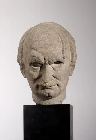 stenen bustesculptuur van een man op een zwart voetstuk
