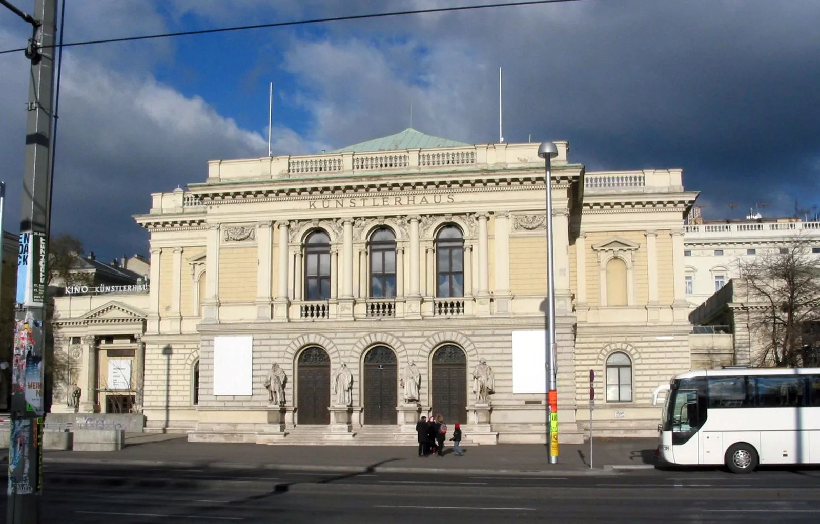 Het Künstlerhaus Wien, een gebouw in klassieke stijl met boogramen en een stenen gevel, onder een bewolkte hemel