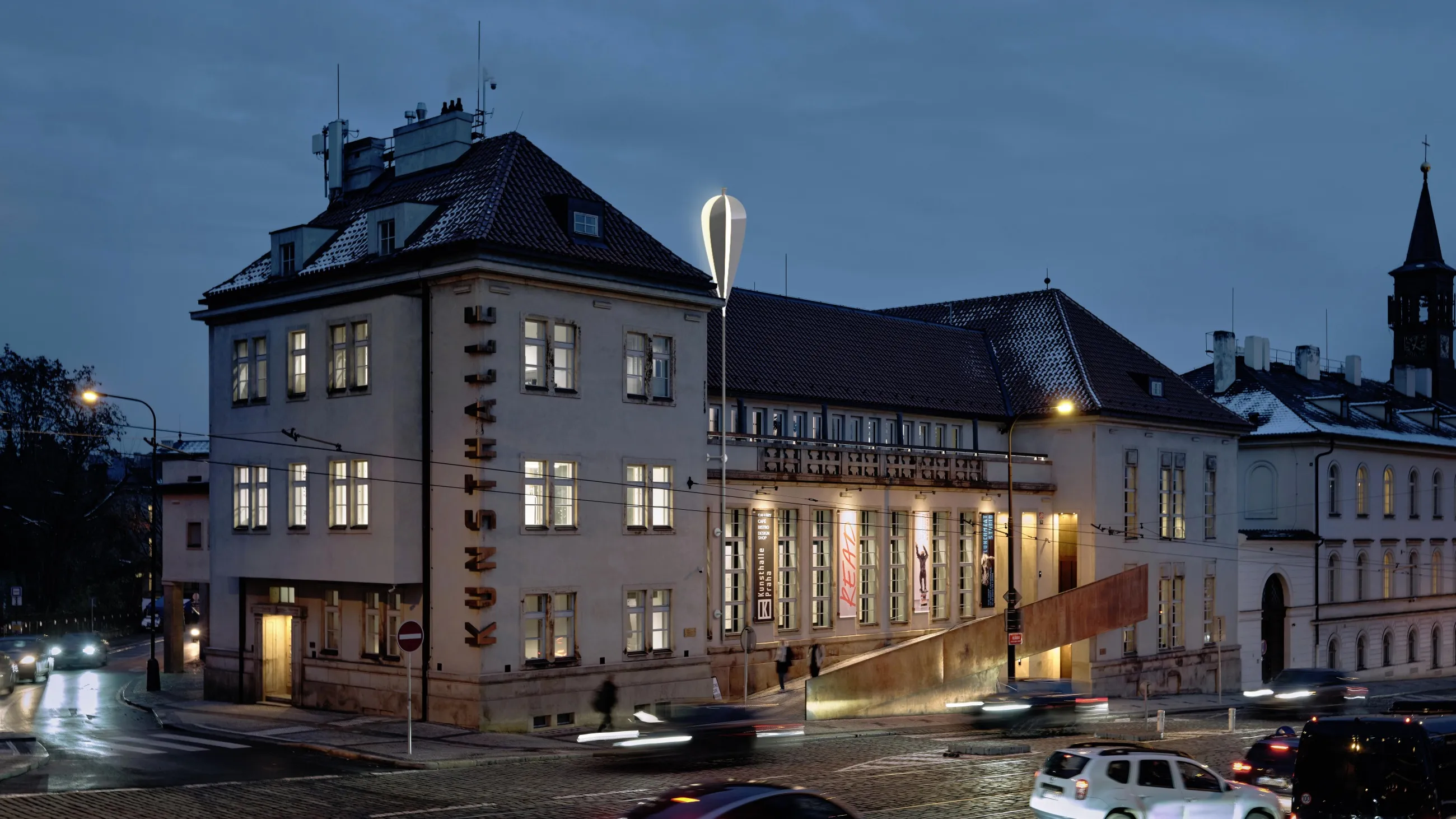 Kunsthalle Praha building at night with illuminated windows and a lit sign on the facade