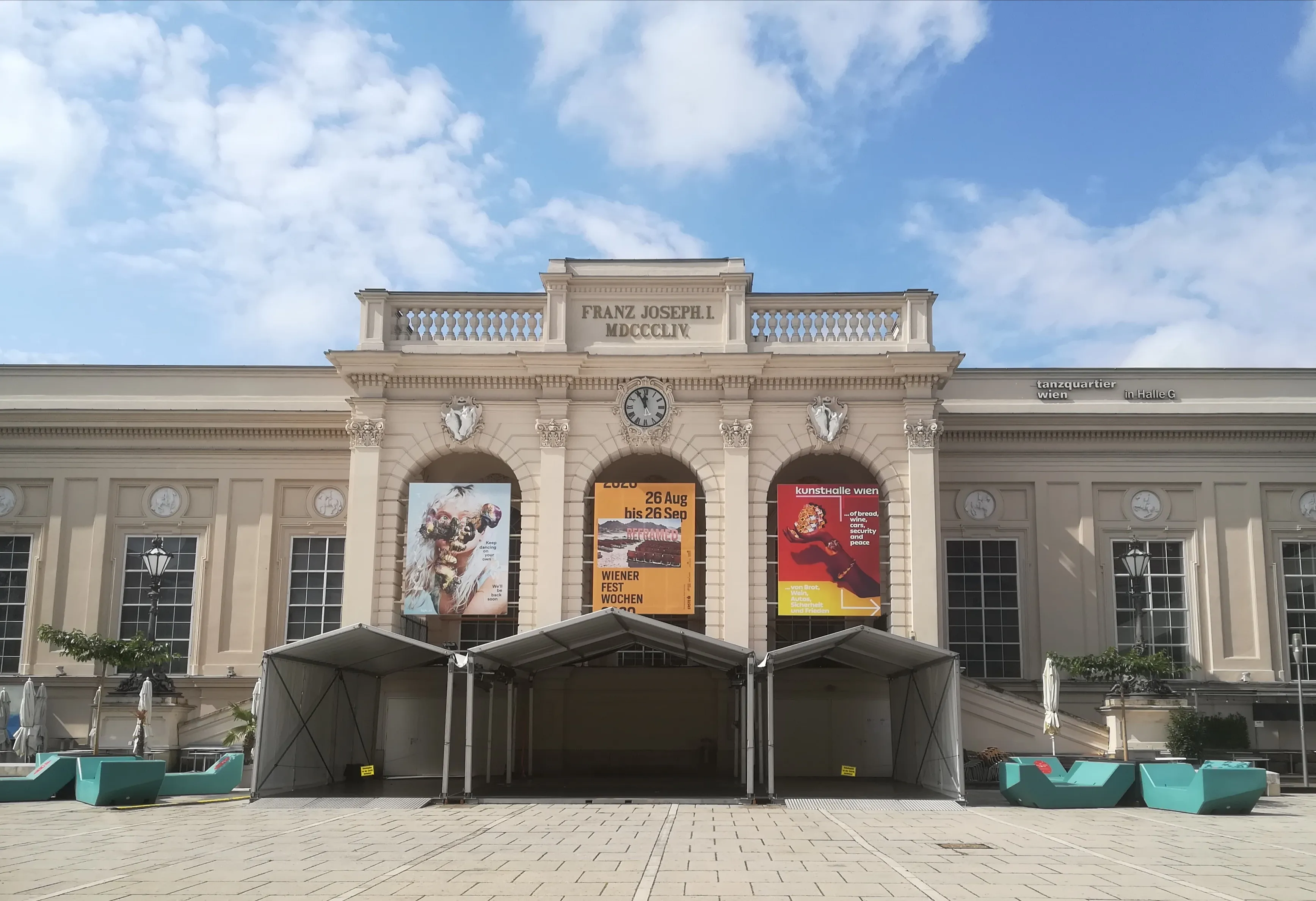 Kunsthalle Wien building with a classical facade, arched windows, and exhibition banners under a blue sky