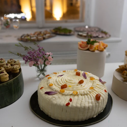 a decorated cake with white frosting and colorful toppings on a black plate