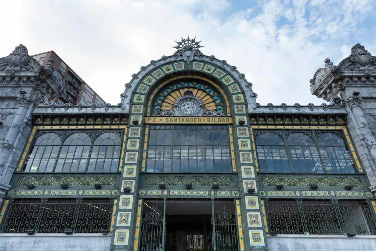 Ornate facade of La Concordia Railway Station featuring colorful ceramic tiles, ironwork, arched windows, and a central sunburst decoration above the entrance