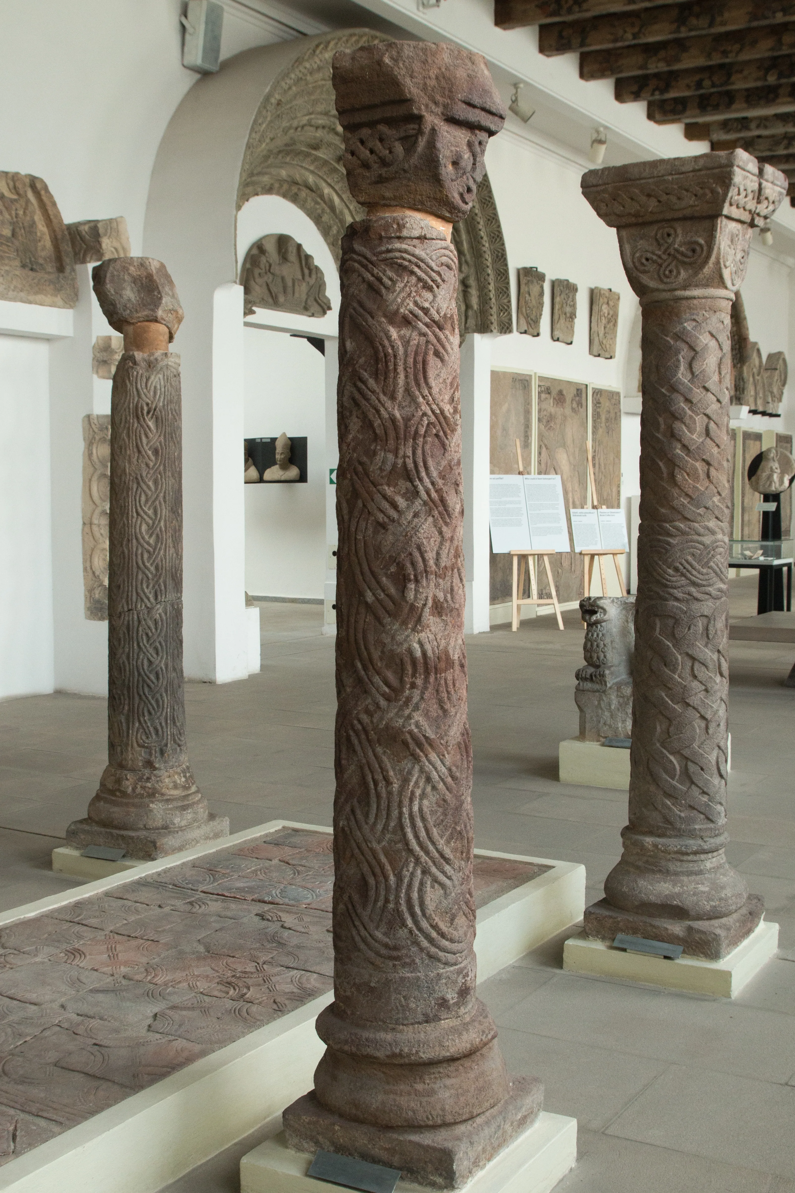 gebeeldhouwde stenen zuilen en architecturale fragmenten in een museumgalerij