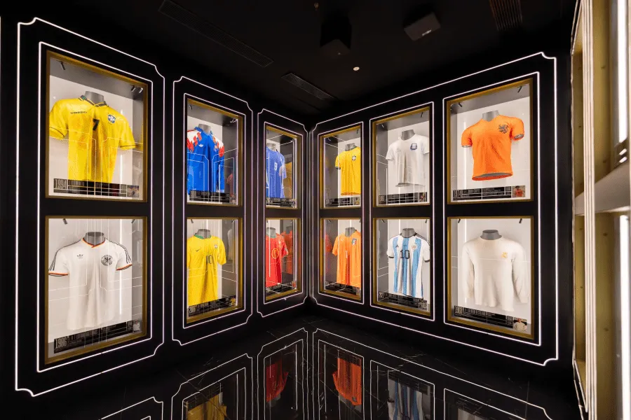 football jerseys in glass display cases on a dark wall