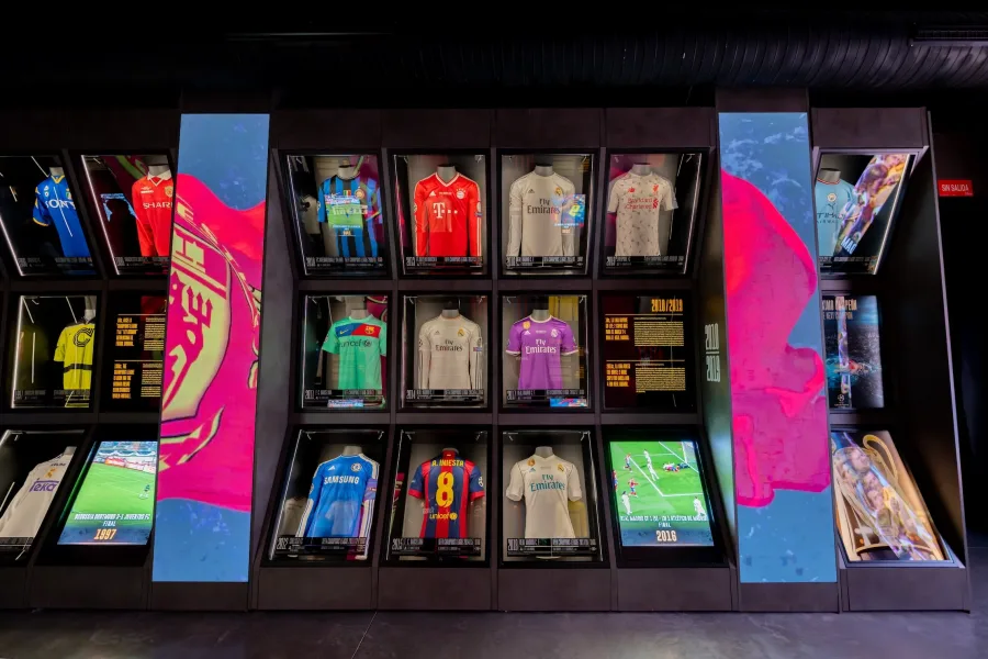 Football jerseys displayed in glass cases with colorful lighting