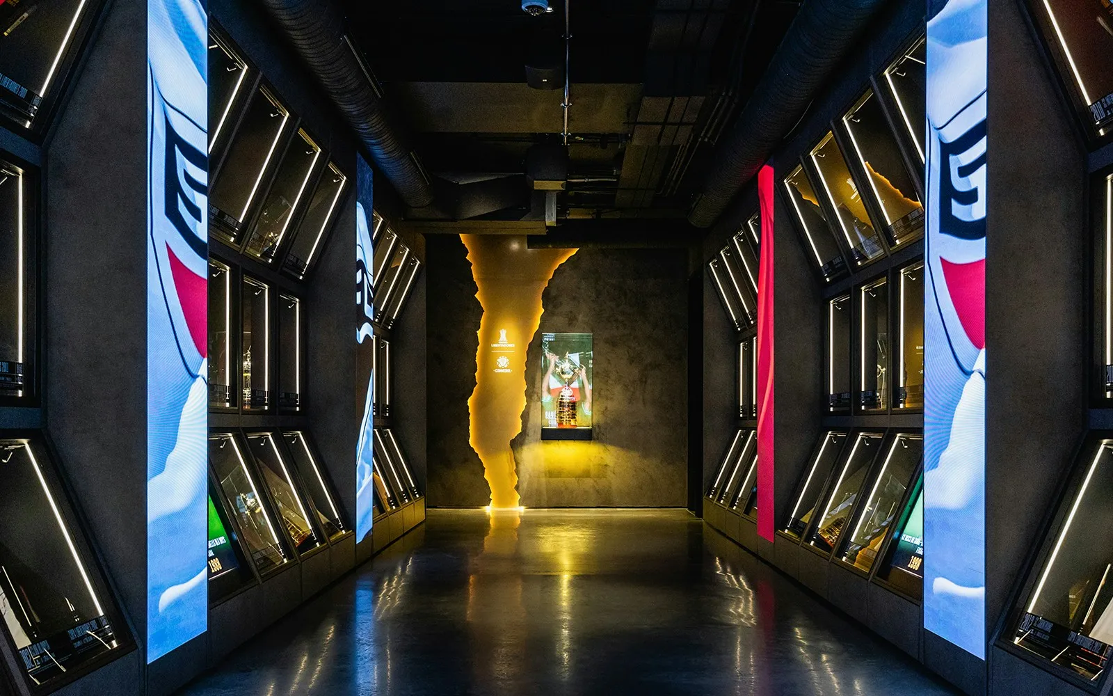 A long corridor with display cases on both sides and a glowing exhibit at the end