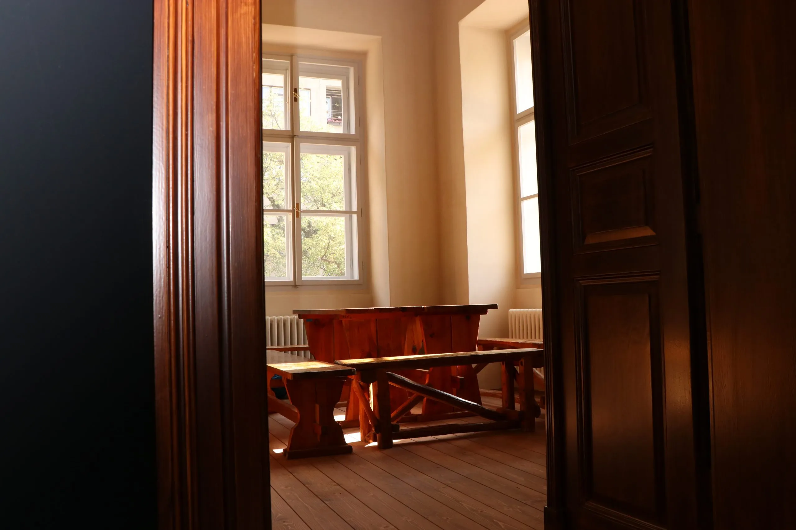 marco de puerta de madera que da a una habitación con una mesa y una ventana