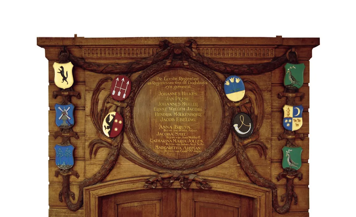 Wooden memorial plaque with engraved text and heraldic shields