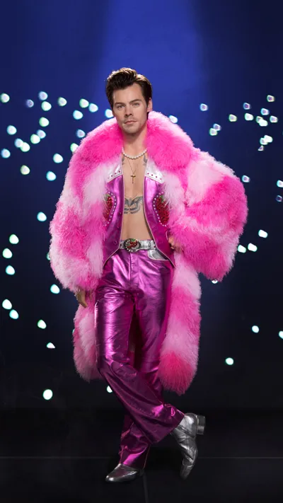 Figura de cera de un hombre con abrigo de piel rosa y pantalones brillantes