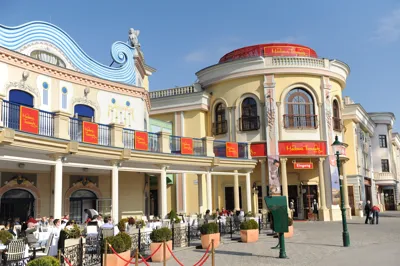 Edificio colorido con diseño de ola azul y señalización roja en la entrada de Madame Tussauds Viena
