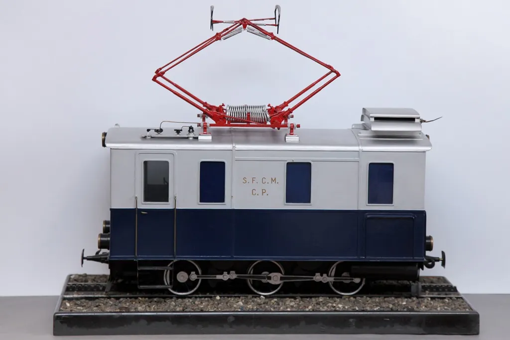 Model of a white and blue locomotive with red pantograph on display