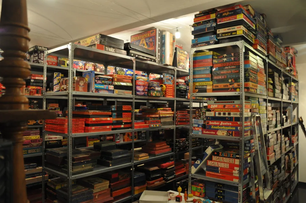 metal shelving units filled with colorful boxes and magic trick sets