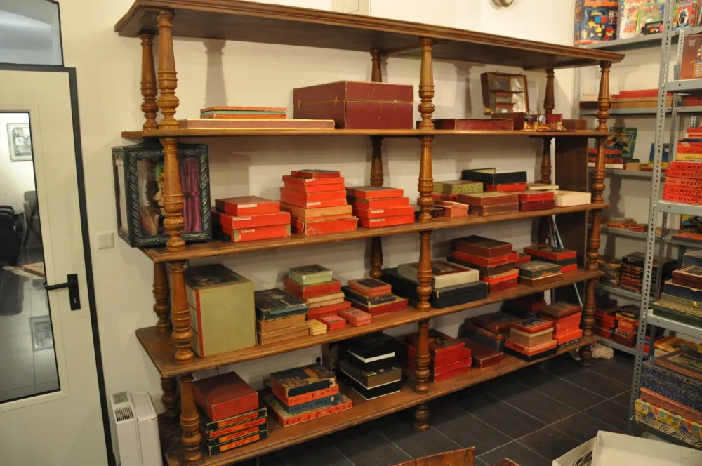 Wooden shelves filled with red, black, and green boxes and books in a museum interior