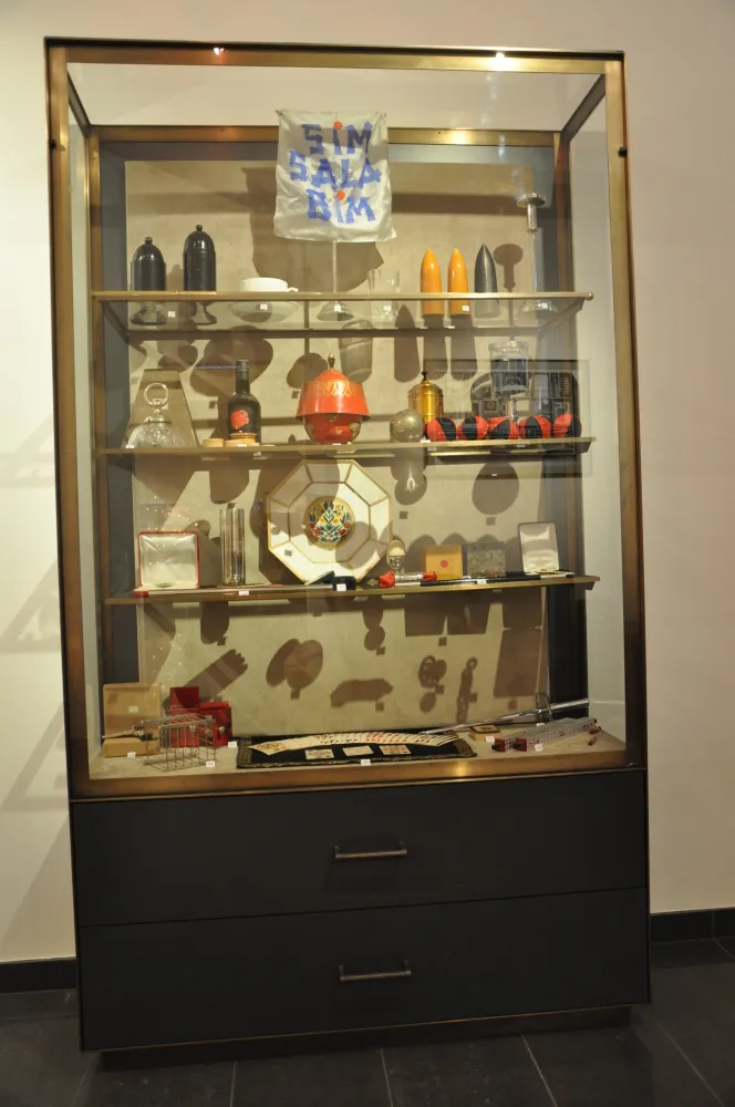 Glass display case with magic props and a sign reading SIM BABA BIM