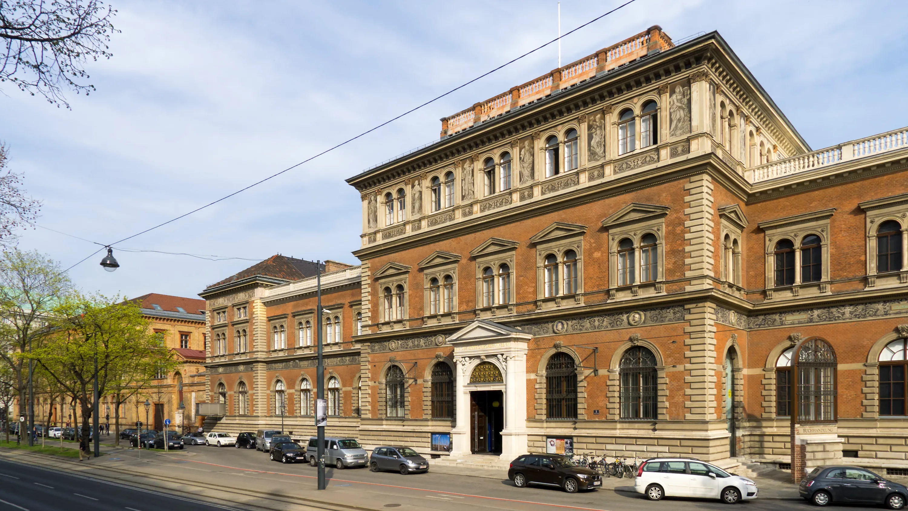 Het MAK - Museum voor Toegepaste Kunst gebouw met een rode bakstenen gevel, rondboogvensters en een centrale ingang onder een blauwe hemel