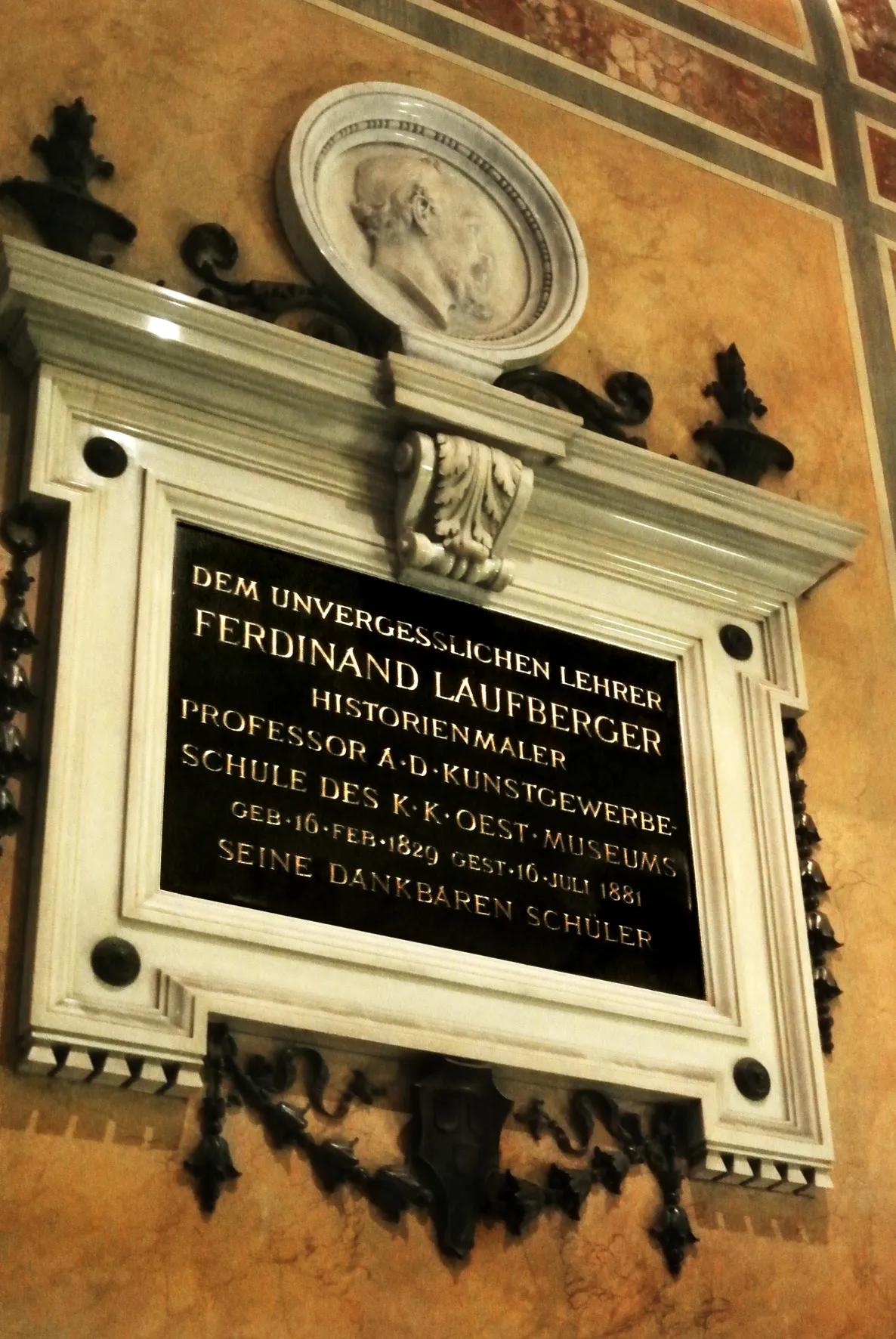 herdenkingsplaquette met Duitse tekst ter ere van Ferdinand Laufberger aan een decoratieve muur