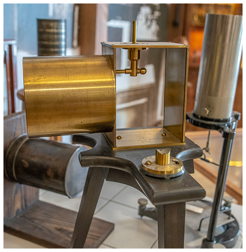 bronze scientific apparatus with cylindrical components and metal frame