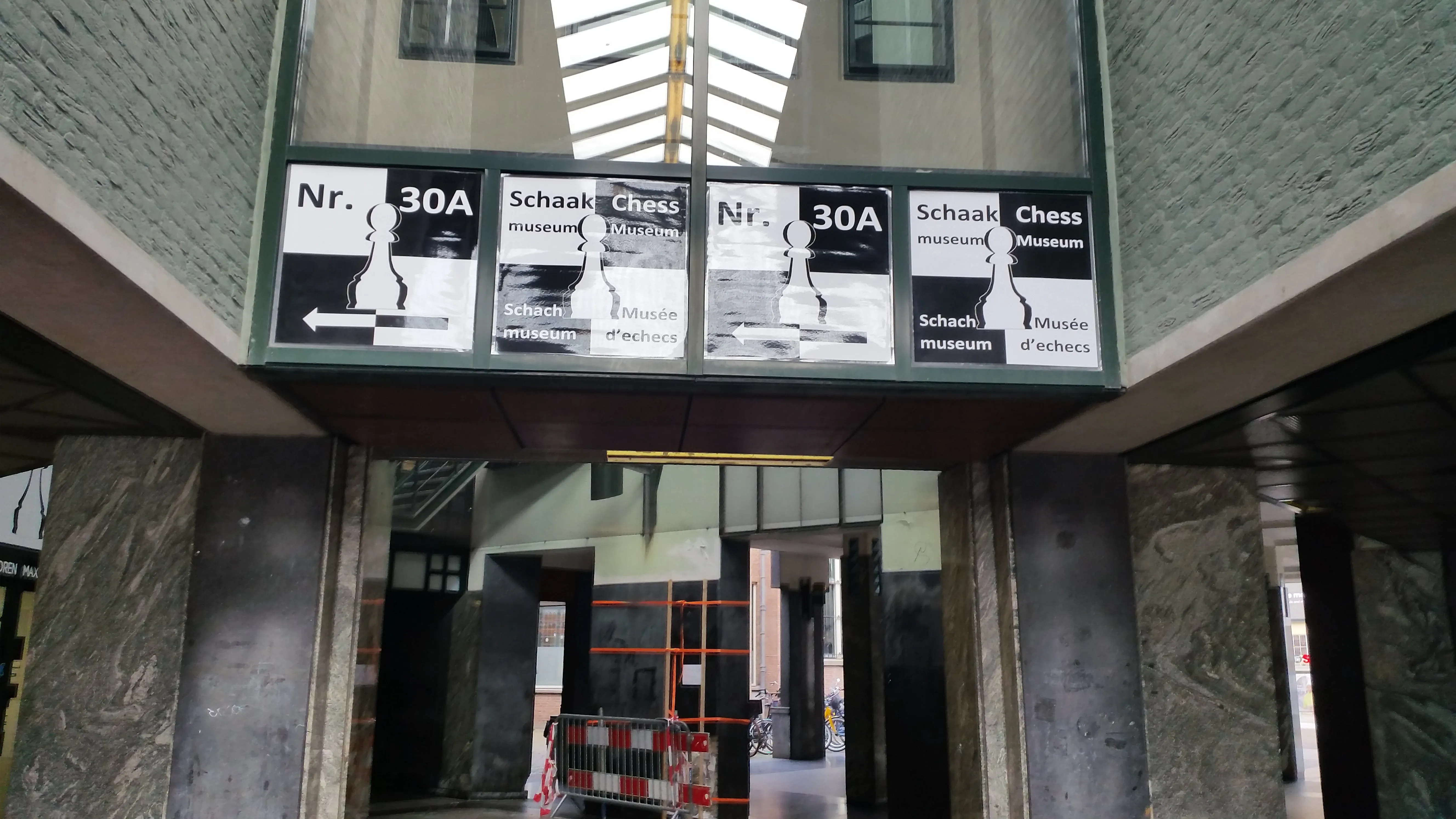 Entrance to the Max Euwe Centrum with a sign displaying 'Nr. 30A' and 'Schaak Museum' in Dutch and English