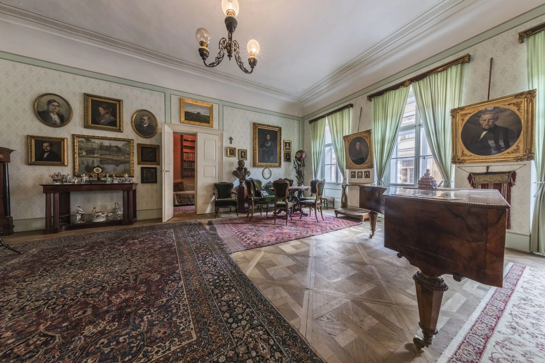 Interieur van een historische kamer met ingelijste portretten, een vleugel en sierlijke meubels