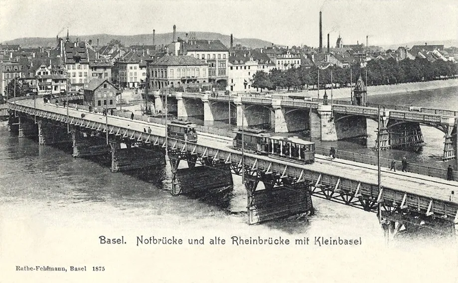 Historische zwart-witansichtkaart met de Mittlere Brücke van Bazel en een tijdelijke houten brug over de Rijn met een tram, circa 1873