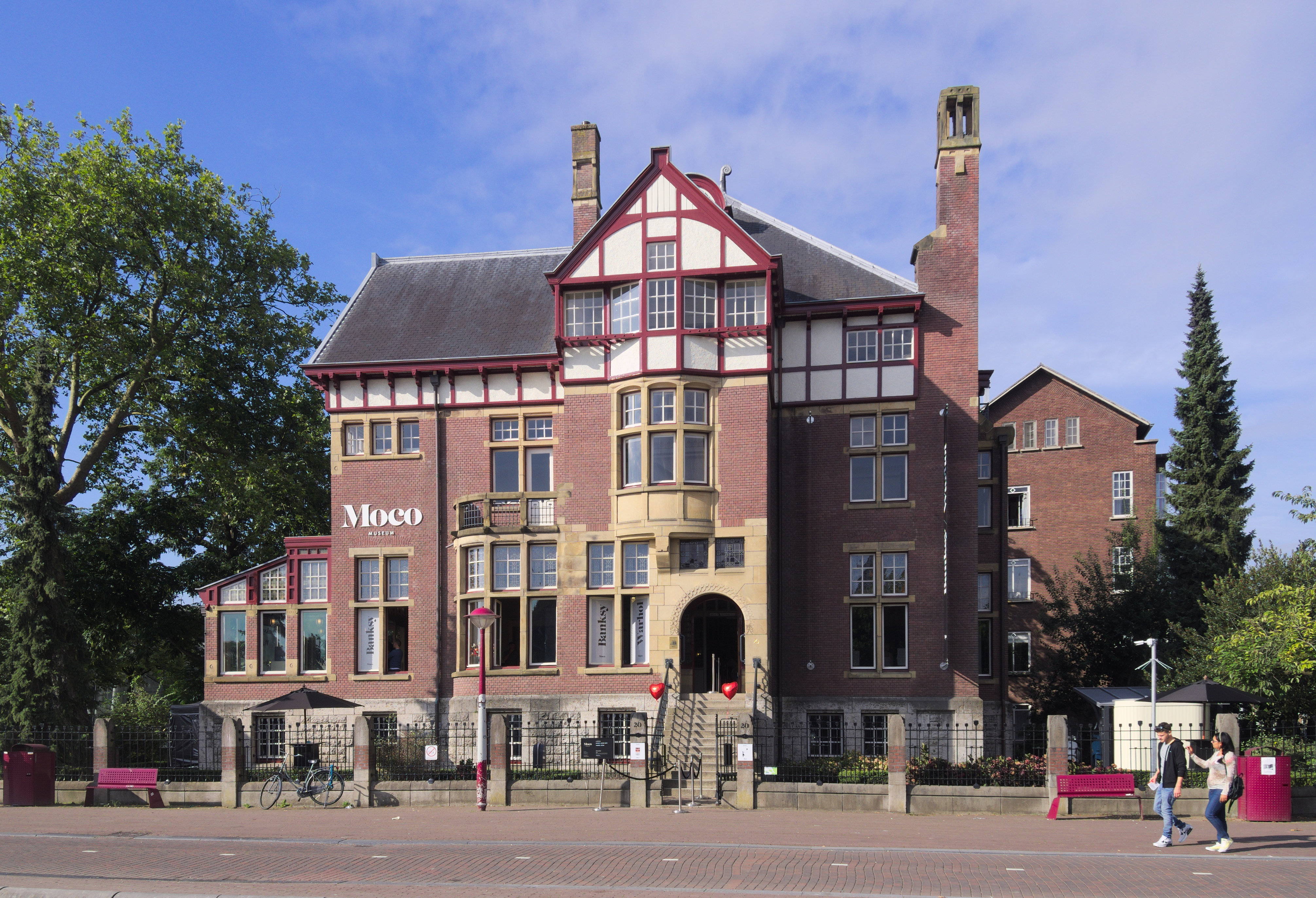 Edificio del Moco Museum, una villa histórica de ladrillo rojo con entramado de madera blanco, con el nombre del museo en su fachada bajo un cielo azul