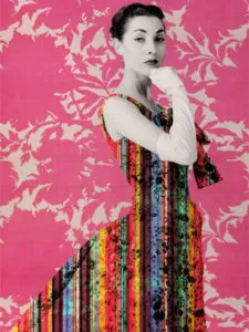 Mujer con un vestido colorido de rayas verticales posando frente a un fondo rosa brillante con patrones de hojas florales blancas