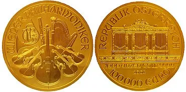 Dwa złote monety, na jednej instrumenty muzyczne i napis 'WIENER PHILHARMONIKER', na drugiej budynek i napis 'REPUBLIK ÖSTERREICH 100000 GULDEN'