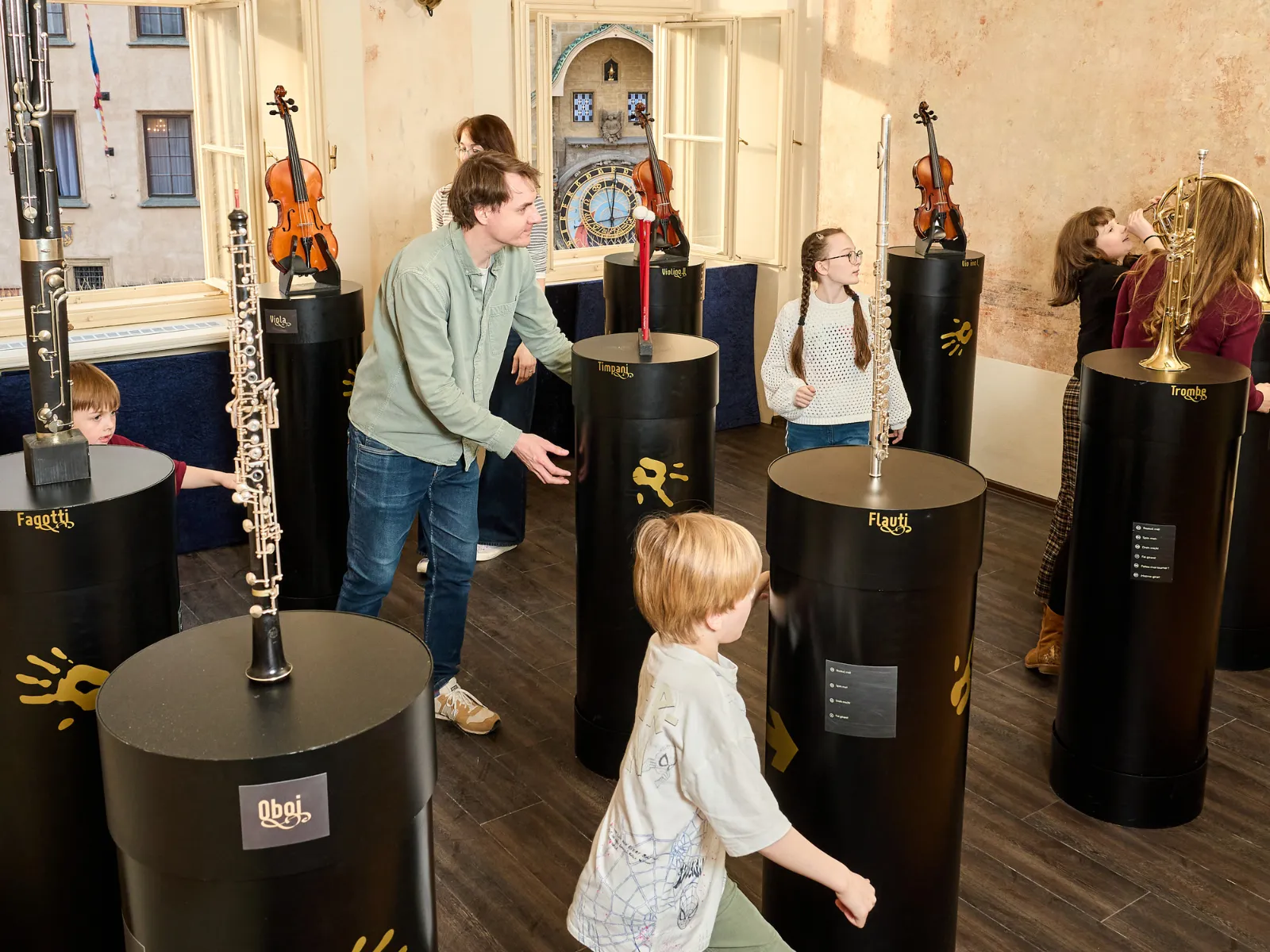 Personas interactuando con instalaciones de instrumentos musicales en una galería de museo