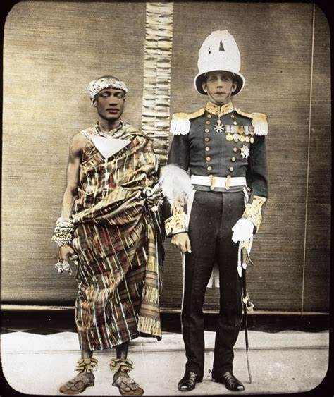 Twee mannen staan samen, de een in traditionele Afrikaanse kleding en de ander in een versierd militair uniform