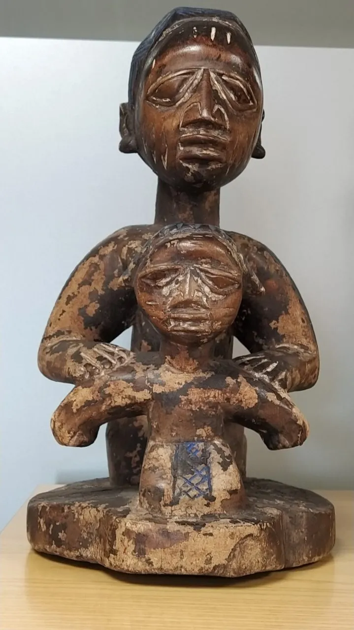 houten beeld van een figuur met een kind op een houten tafel