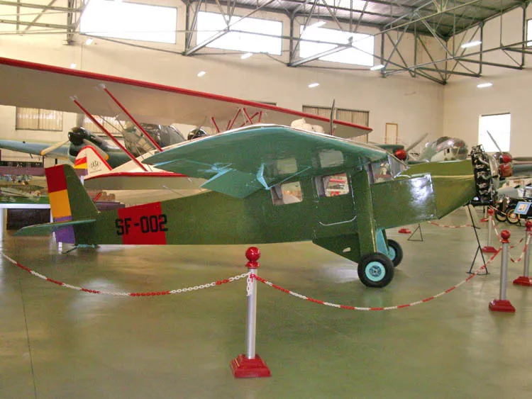Groen vintage vliegtuig met SF-002 markeringen tentoongesteld in een museumhangaar