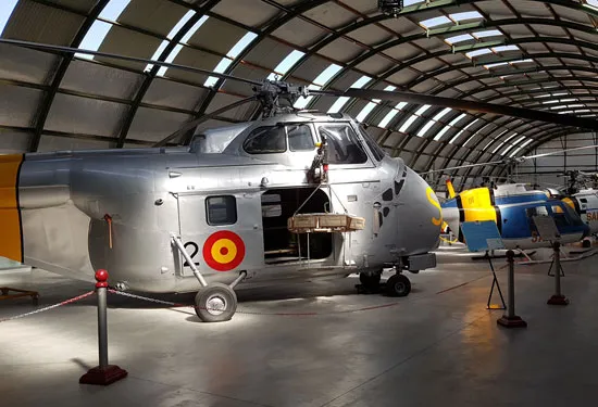 Zilveren helikopter met Spaans militair luchtvaartrondel in een hangar