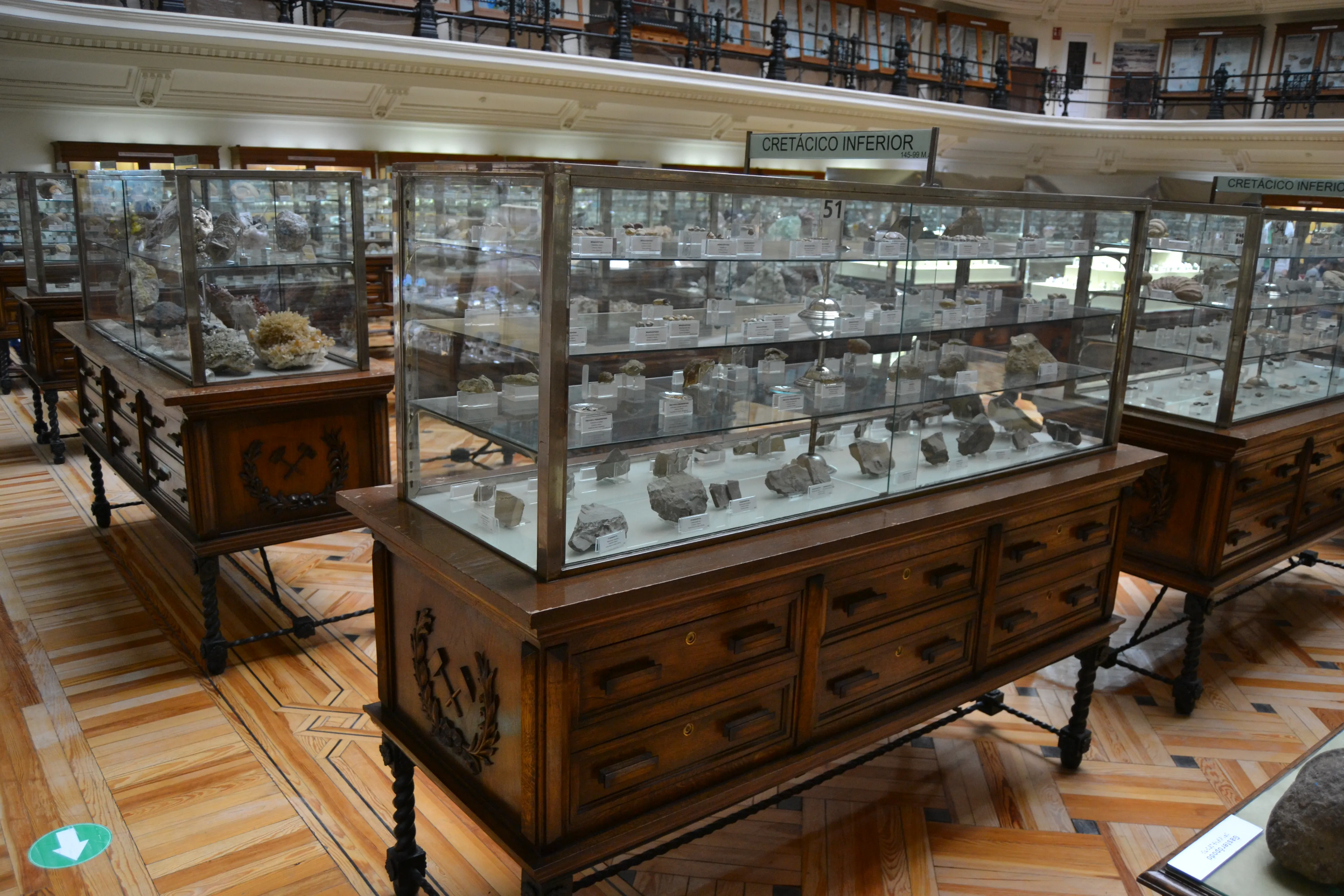 houten vitrines met glazen bladen waarin mineralen liggen in een museumzaal
