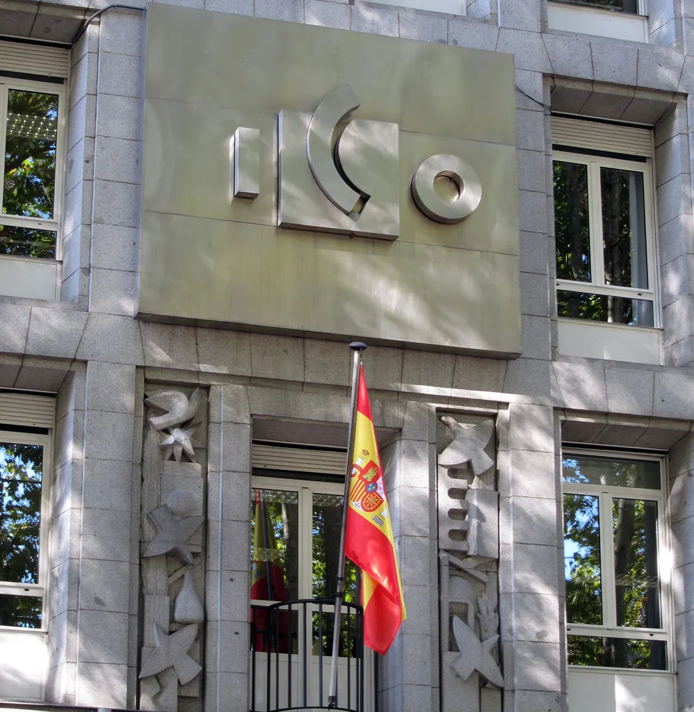 Museo ICO gebouwgevel met een groot ICO-logo op een stenen paneel boven de ingang en een Spaanse vlag ervoor