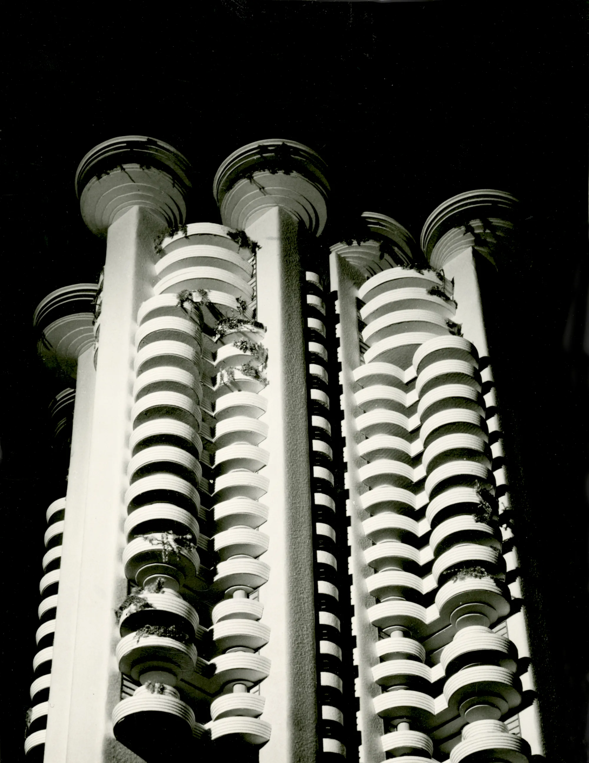 Close-up van witte spiraalbalkons op de gevel van een modern gebouw 's nachts