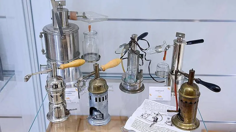 Historical medical sterilization equipment on display in a glass case
