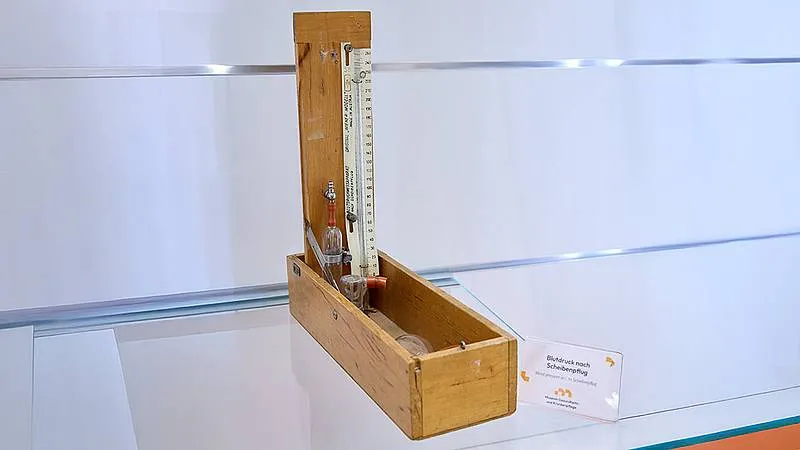 wooden box with a vertical gauge and glass components on display