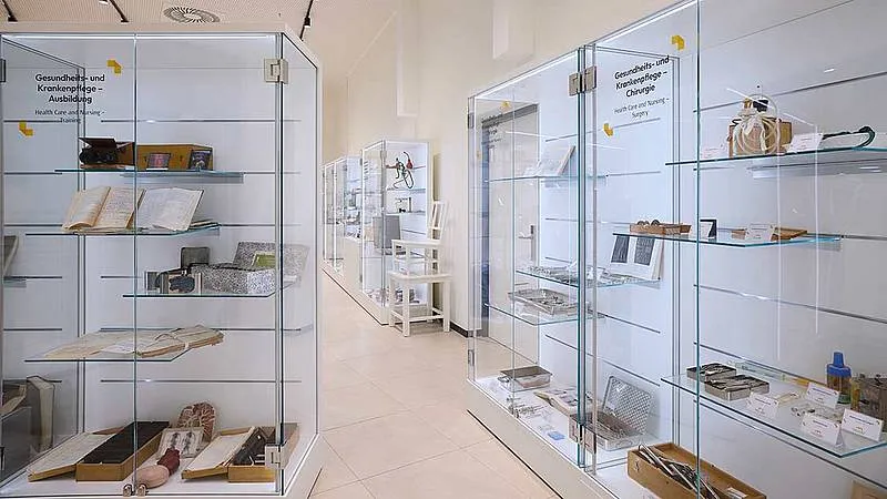hallway with glass display cases containing medical artifacts and documents