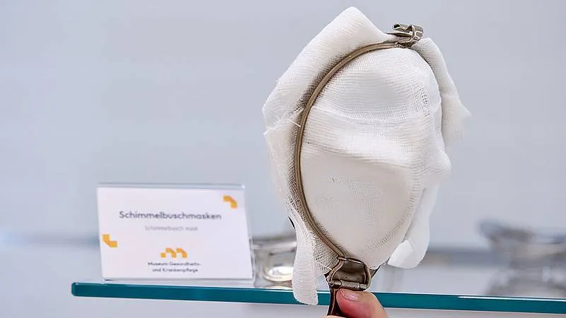 white fabric nursing mask with metal frame on display with a label