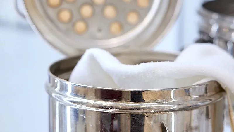 close-up of a metallic container with a white cloth inside