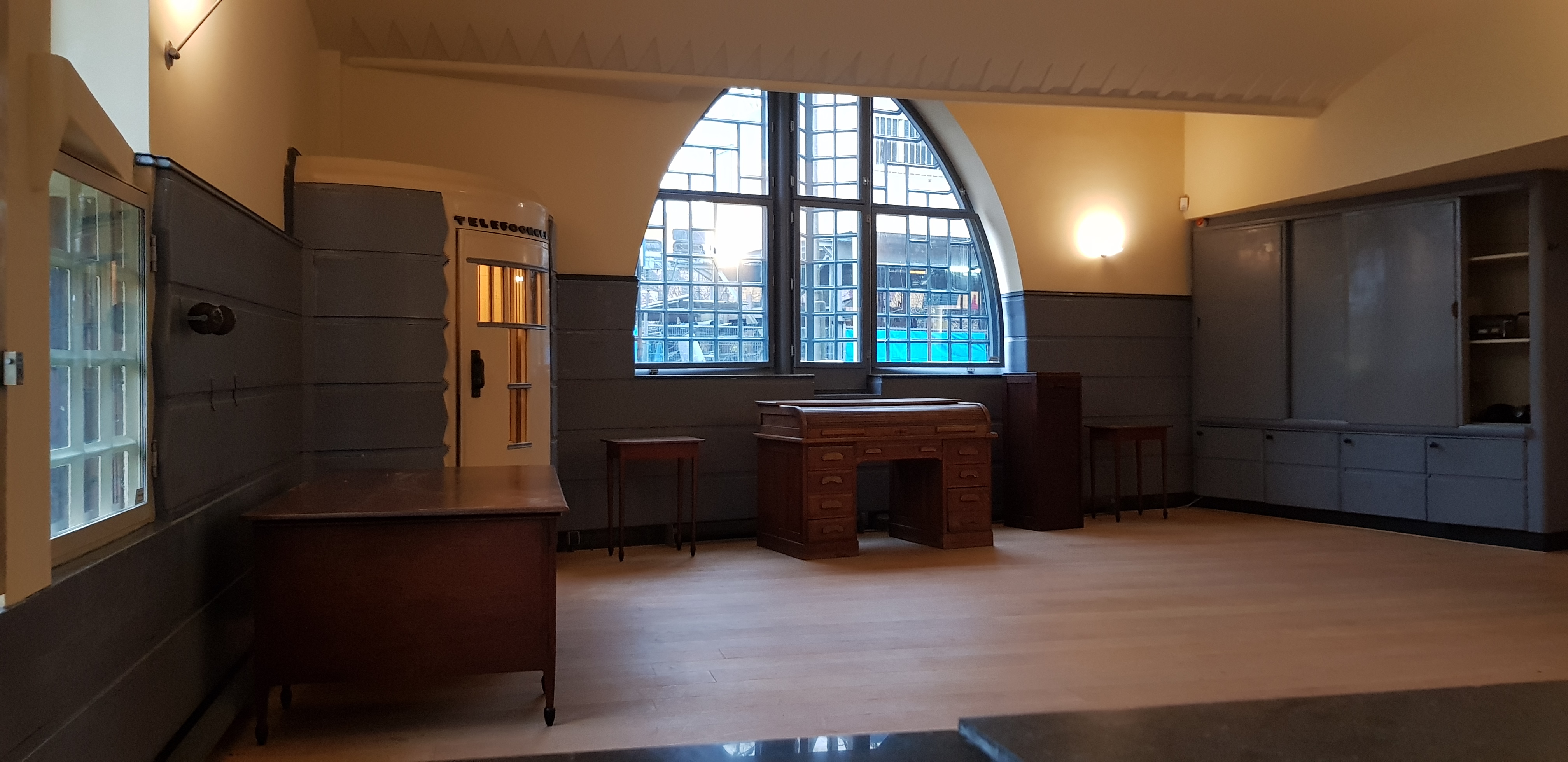 Interior of Museum Het Schip with wooden furniture, a large arched window, and a reception desk