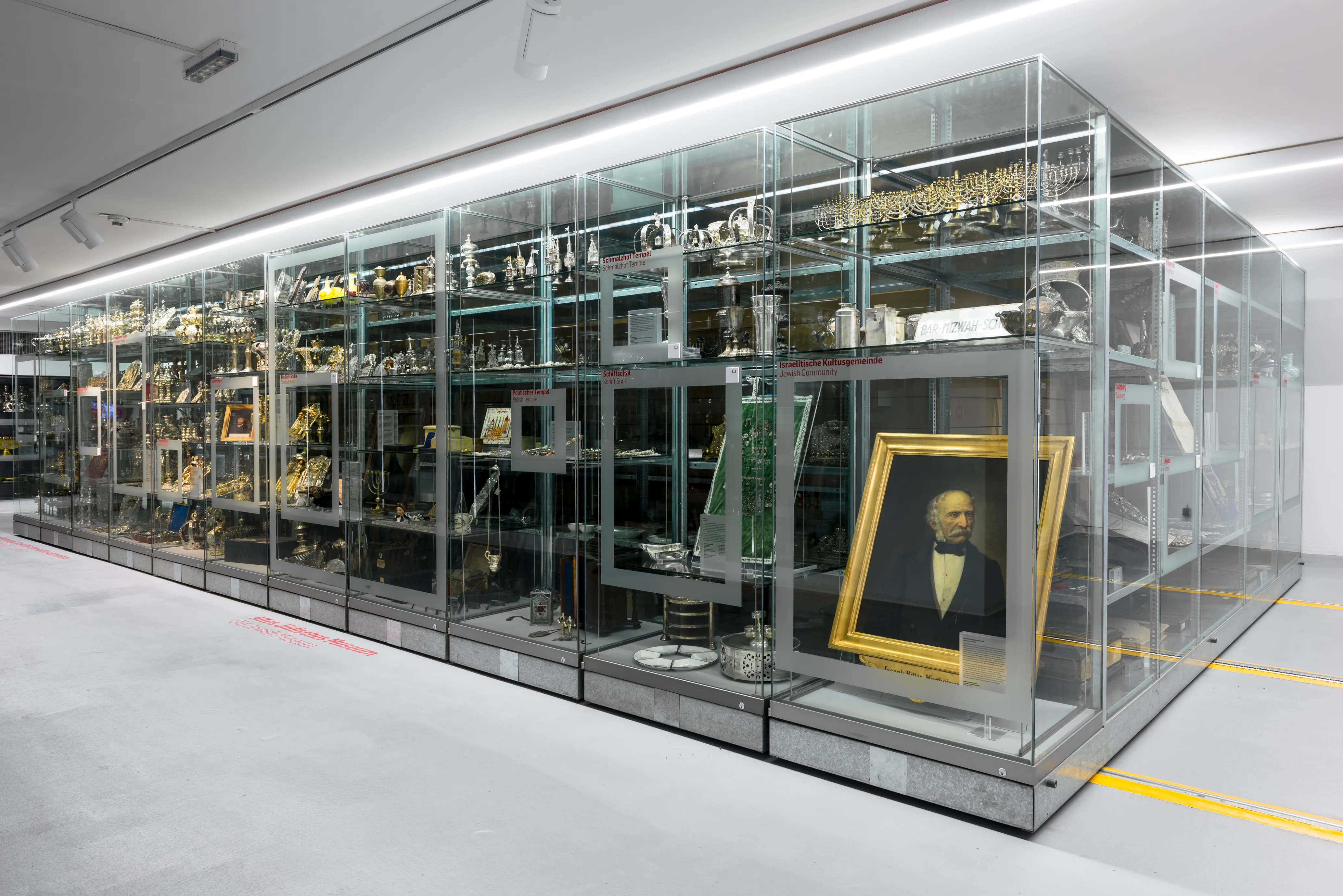 Glazen vitrine met museumartefacten en een ingelijst portret