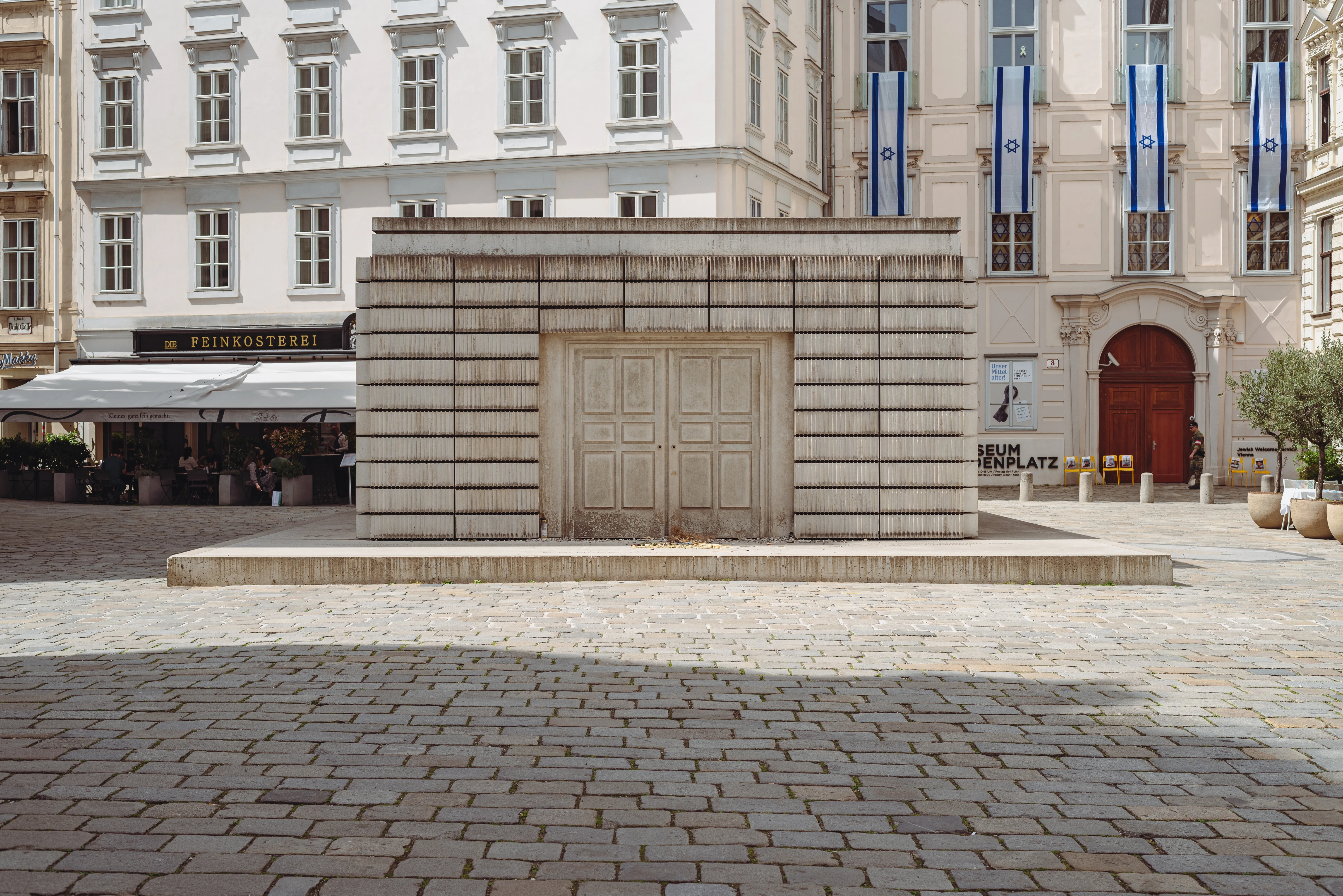 Pomnik Ofiar Holokaustu na Judenplatz z kamienną konstrukcją i zamkniętymi drzwiami na brukowanym placu