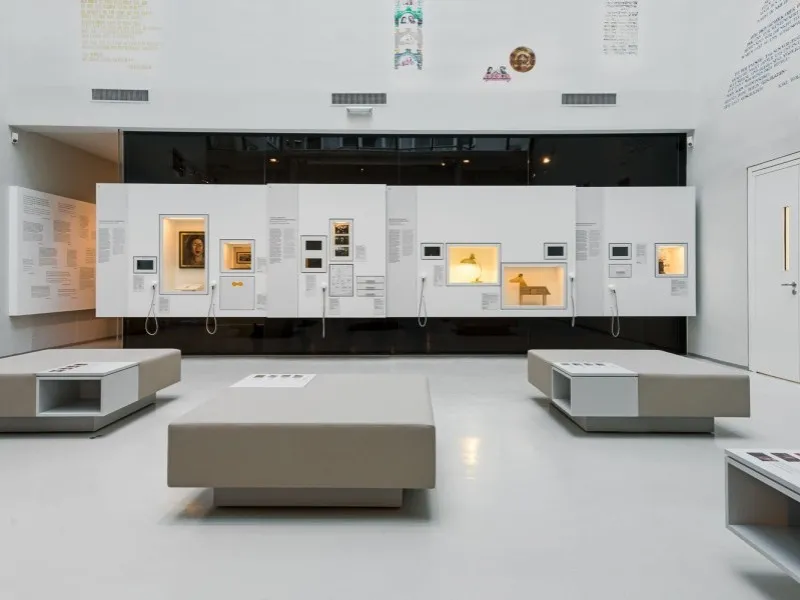 Moderne museuminterieur met witte vitrines en verlichte panelen