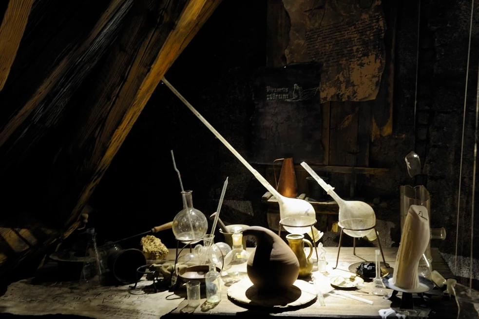 alchemical apparatus and equipment on a table in a dark room