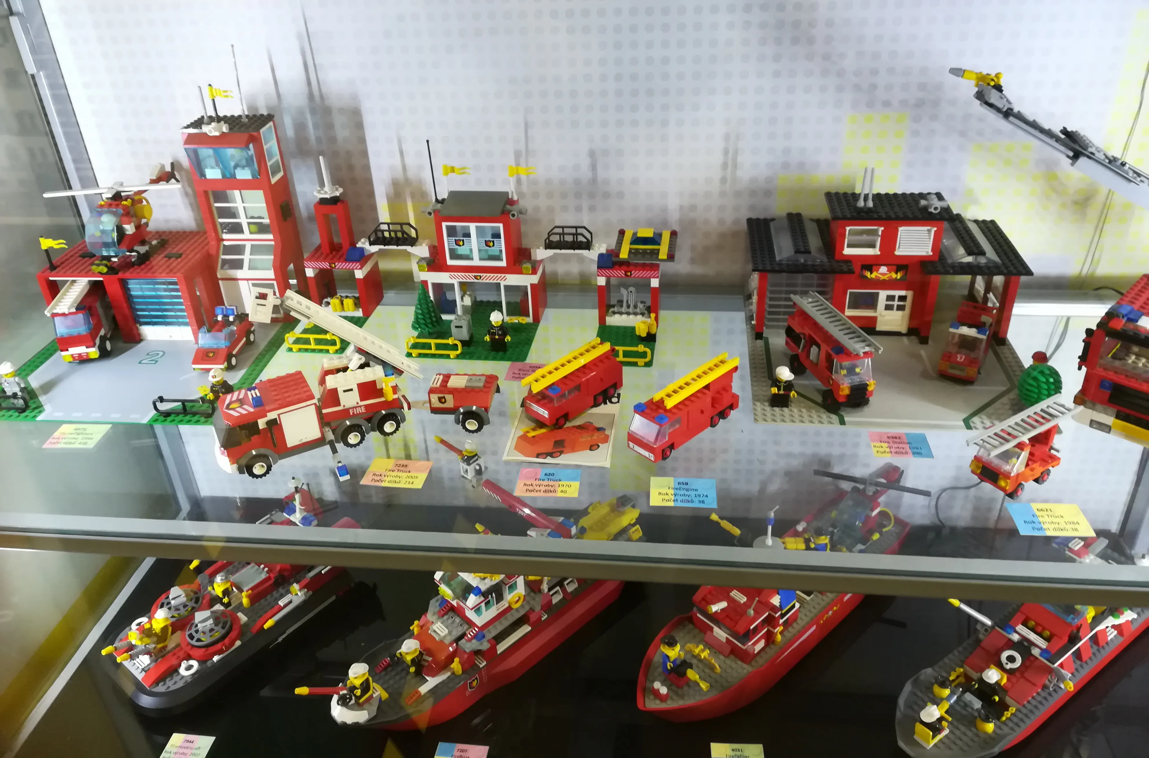 LEGO-modellen van brandweerkazernes, brandweerwagens en boten tentoongesteld in een vitrine
