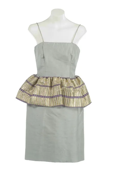 Vestido gris claro con cintura peplum y tejido a rayas doradas y púrpuras en un maniquí