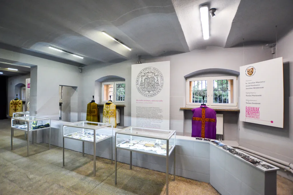 Interieur van een museum met vitrines, informatieborden en historische kledingstukken
