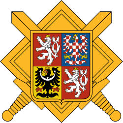 A golden emblem with four heraldic shields featuring lions and an eagle, crossed swords, and a diamond-shaped border