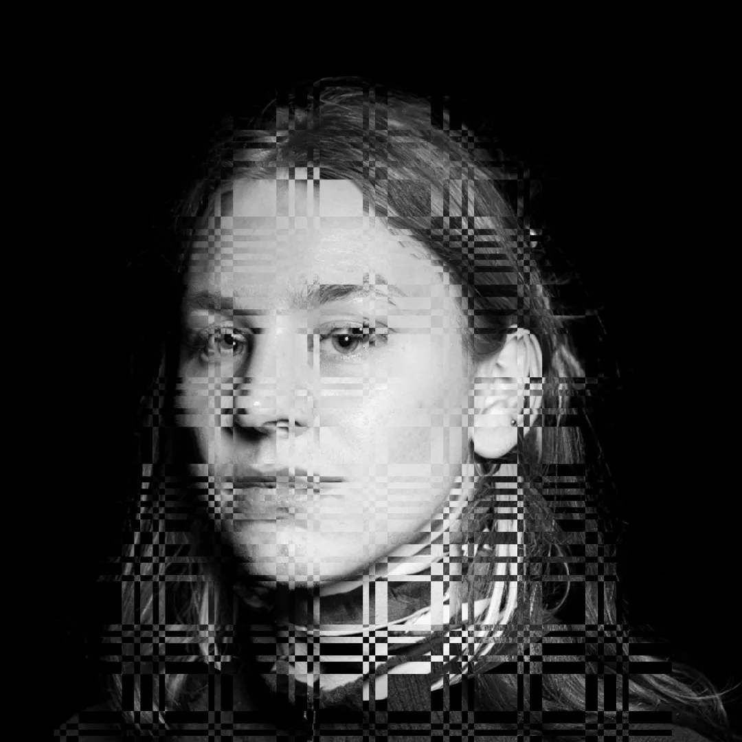 Czarno-biały portret osoby z cyfrowymi efektami glitch i pikselizacji nałożonymi na twarz i włosy na czarnym tle.